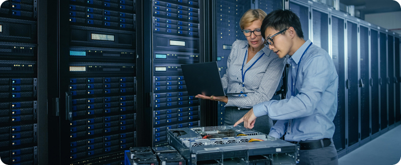 IT professionals examining server rack connections and network switches in a data center.